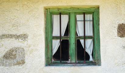 Obraz premium Aged wooden window with glazing and partially weathered in rustic homes