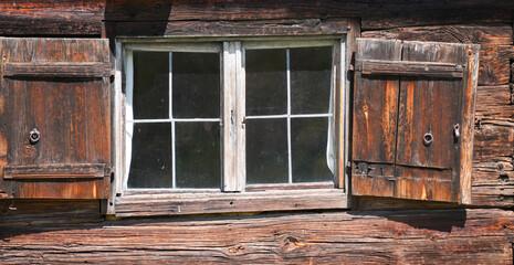 Aged wooden window with glazing and partially weathered in rustic homes