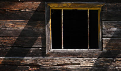 Fototapeta na wymiar Aged wooden window with glazing and partially weathered in rustic homes