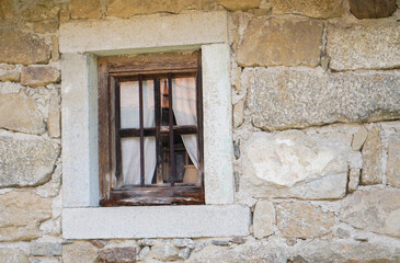 Fototapeta na wymiar Aged wooden window with glazing and partially weathered in rustic homes