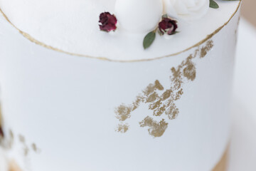Obraz na płótnie Canvas Texture of gold foil spots on white cake. Elegant white wedding cake with gold foil design. Wedding photo.