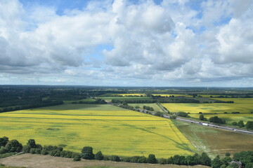 Fototapeta premium Aerial view of farmland and roads with a cloudy sky background. 