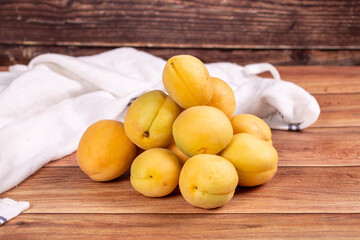 Naklejka na ściany i meble Apricots on wood background. Pile of fresh apricots. close up