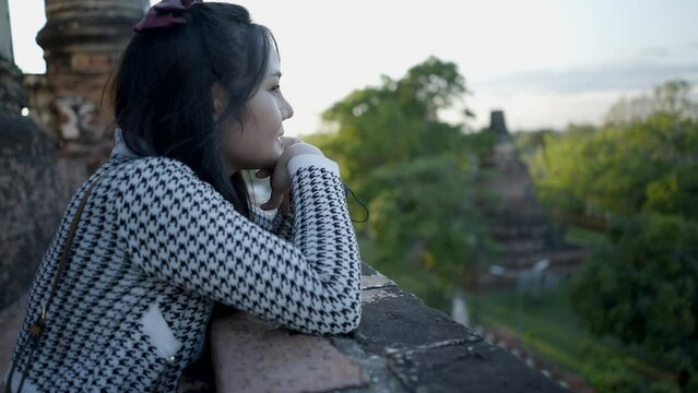 Young teenage Thai girl enjoy sunset view from Wat Yai Chai Mongkhon temple in Ayutthaya,Thailand