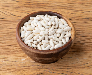 White beans in a bowl over wooden table
