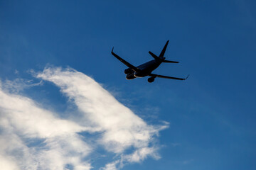 Fototapeta na wymiar Flight of the plane on the background of a beautiful cloudy sky.