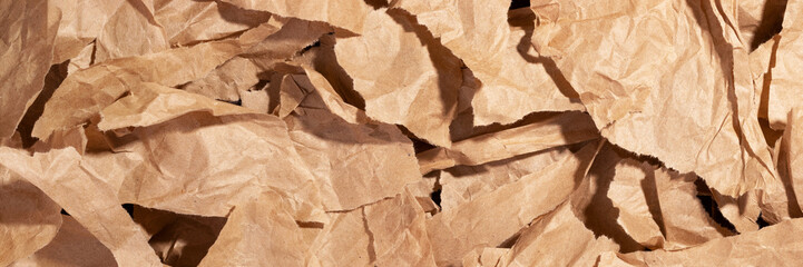 Multiple pieces of torn brown crumpled, wrinkled recycle craft paper background texture, top view banner. Wide panoramic header