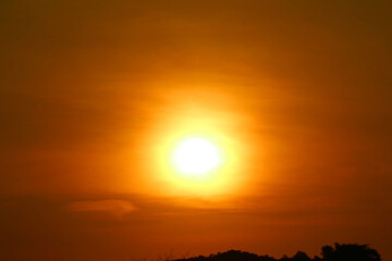 Gorgeous bright sun rising on the orange-gold sky