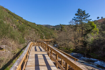 Fototapeta na wymiar The river hiking trail Ecovia do Vez near Arcos de Valdevez, Portugal. Ecovia do Vez wooden pathways along the riverside.