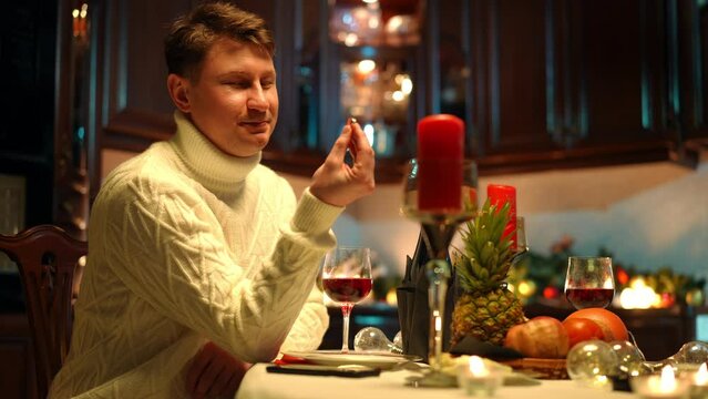 Thoughtful loving man taking out engagement ring from pocket admiring jewelry smiling. Portrait of happy relaxed Caucasian boyfriend preparing romantic dinner and proposal for partner indoors