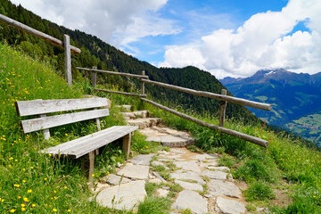 a bench overlooking the alpine valley of the city Merano surrounded by the Texel group mountains...