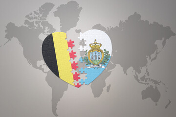 puzzle heart with the national flag of belgium and san marino on a world map background.Concept.