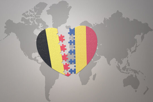 puzzle heart with the national flag of belgium and romania on a world map background.Concept.