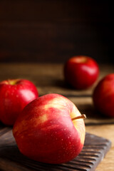 Fresh ripe red apples on wooden table. Space for text