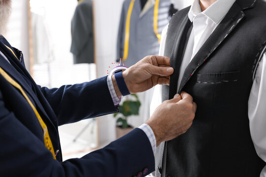 Professional tailor working with client in atelier, closeup