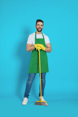 Man with yellow broom on light blue background