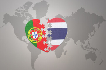 puzzle heart with the national flag of portugal and thailand on a world map background.Concept.