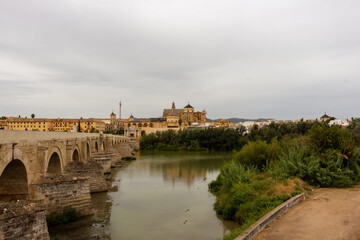 Cordoba, Spain, September 13, 2021: Guadalquivir River and the Roman Bridge, with Cordoba Mosque-Cathedral in the background.
