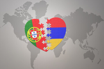 puzzle heart with the national flag of portugal and armenia on a world map background.Concept.