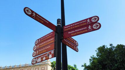 Sevilla, Spain, September 12, 2021: Sign post indicating the direction of tourist places of the  European city of Seville. Direction signs for attractions.