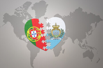 puzzle heart with the national flag of portugal and san marino on a world map background.Concept.