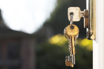 House keys in lock of door viewed outside horizontal
