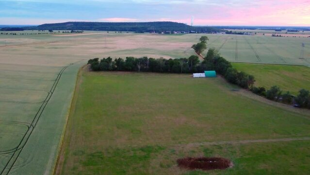 Dung heap on meadow Cornfield.
Perfect aerial view flight rising up drone footage
at Countryside village Hainichen in Europe Saxony Anhalt, summer 2022. 4k Cinematic view from above by Philipp Marnitz