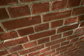 Above closeup of a wall of red brick still life. Hard solid building material with rough texture on...