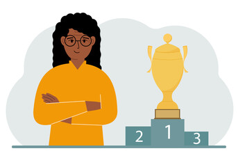 A woman next to the pedestal on which the cup for victory and first place.