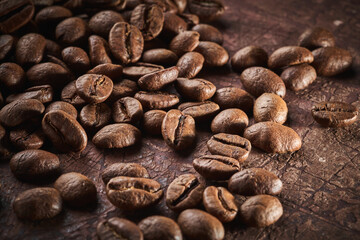 Roasted coffee beans isolated close up on brown grunge background