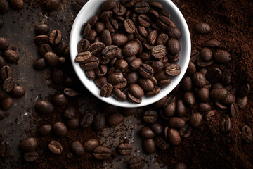Roasted coffee beans in bowl isolated close up on brown grunge background