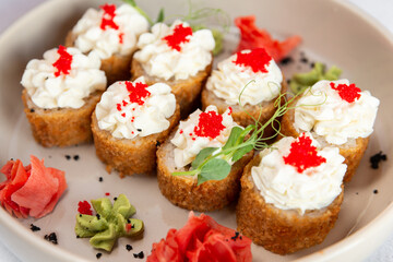 Gunkan-maki sushi on a pale blue plate close up
