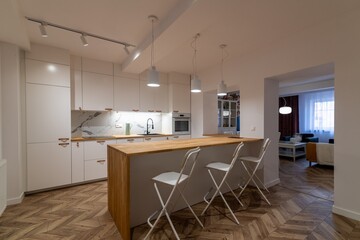 Modern apartment kitchen with a counter and three bar stools