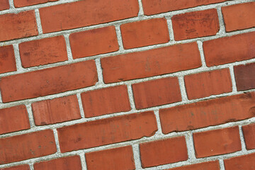 Obraz premium Closeup of a red brick wall with copy space. Detail of recently built exterior masonry or historic design wall background patterns and textures. Outside zoom of modern industrial style architecture