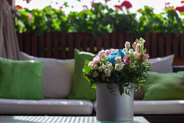 A rose bouquet in a box on a summer terrace. A bouquet of pink and white roses decorated in a hat box created by a florist.