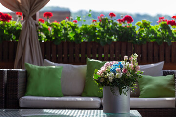 A rose bouquet in a box on a summer terrace. A bouquet of pink and white roses decorated in a hat box created by a florist.
