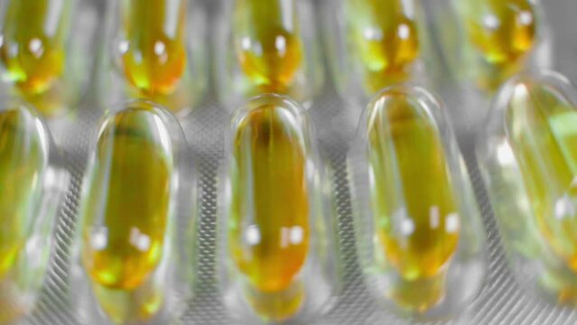 Packaging with fish oil capsules close-up swirling