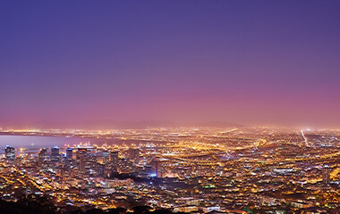 Fototapeta premium Cape Town after sunset, a cityscape view from Signal Hill, South Africa. Bright lights over a city landscape on a beautiful summer evening. panoramic of the city. Illuminated buildings and streets