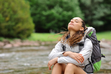 Trekker resting and breathing in a riverside