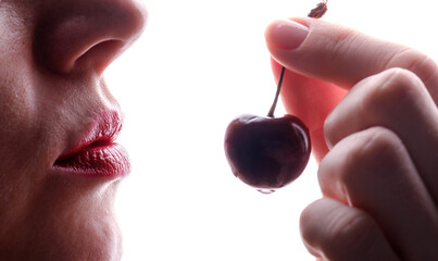 female lips and cherry berry on a white background