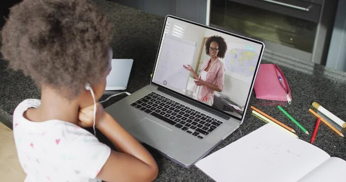 African american girl using laptop for video call, with female teacher on screen