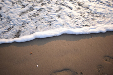 White wave of blue sea on sandy beach. Natural background
