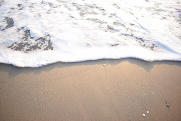 White wave of blue sea on sandy beach. Natural background