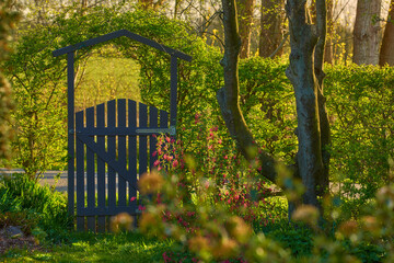 Small wooden gate in the countryside. Lush green garden upon entrance to private home in the...