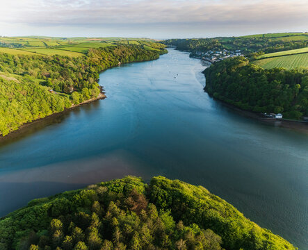 Aerial view looking down the river Lerryn above the treetops at sunset, Lostwithiel, Lerryn, Cornwall, United Kingdom.