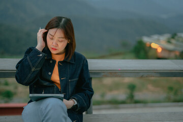 asian woman use tablet for stock and cryptocurrency trading from outdoor of coffee shop