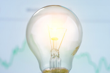Classic electric light bulb on blurred background trend infographic. The concept of the energy...