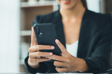 young businesswoman looking at financial information from a mobile phone, she is checking company financial documents, she is a female executive of a startup company. Concept of financial management.