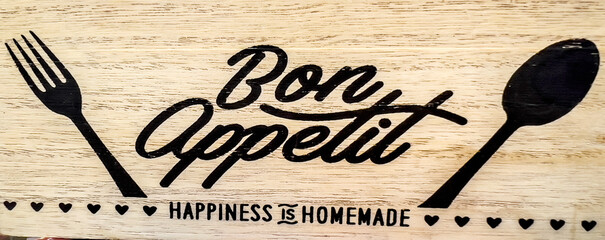 Bon Appetit sign with fork and spoon on wooden background 