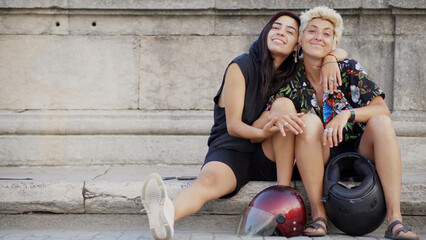 Retrato de una pareja gay alternativa con cascos de moto